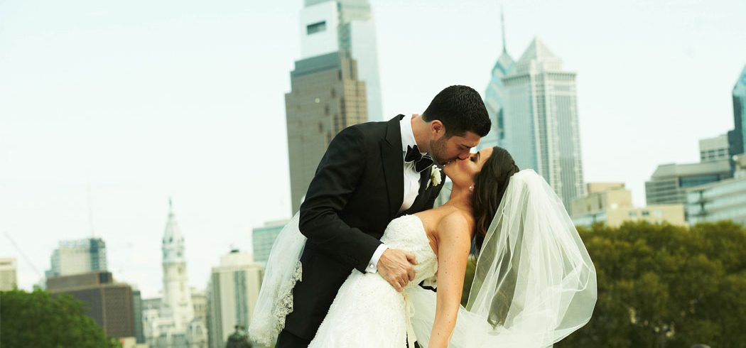 Groom dips Bride and kissed during outside wedding portraits in Philadelphia, PA - Event Planner