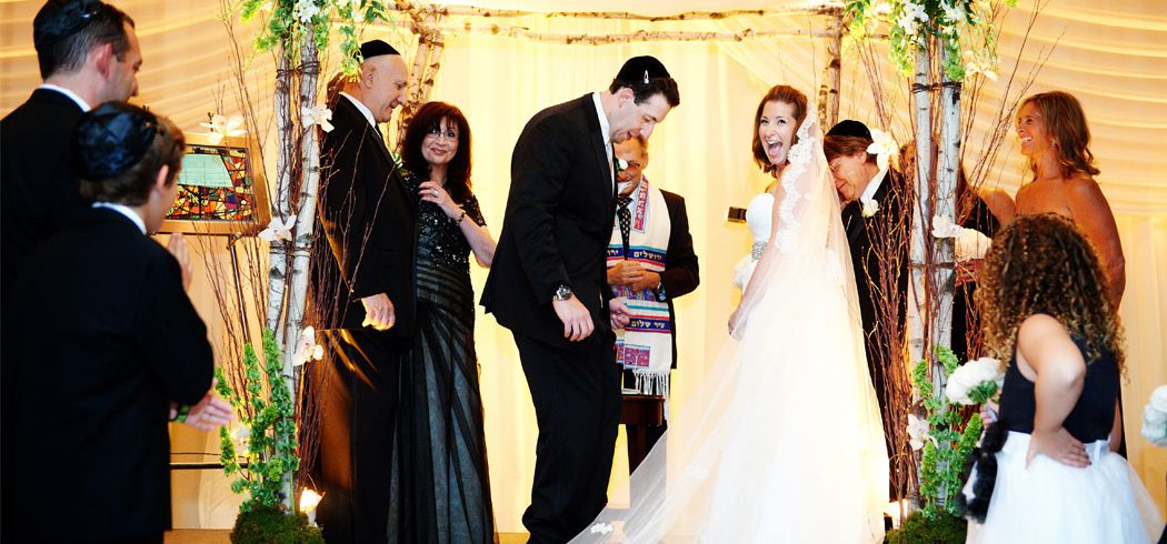 Bride and Groom laugh during Jewish wedding ceremony in Philadelphia, PA - Event Planner