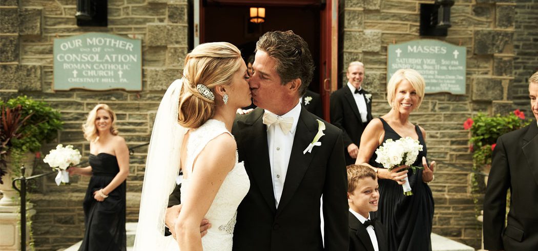 Bride and Groom kiss outside church at wedding in Philadelphia, PA - Event Planner